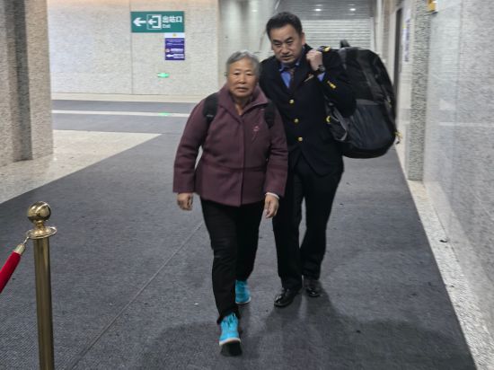 图为刘桂强帮助旅客扛包送出站 朱国锋 摄 图为刘桂强帮助旅客扛包送出站 朱国锋 摄