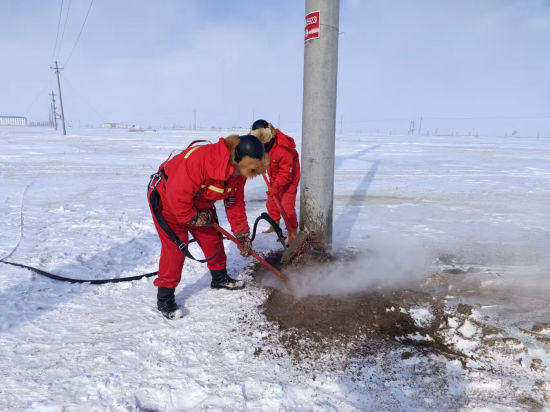 抢修队员用蒸汽枪解冻断裂电杆的基础 抢修队员用蒸汽枪解冻断裂电杆的基础