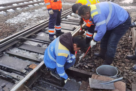 图为北安信号车间职工对道岔进行整治 齐鸣远 摄 图为北安信号车间职工对道岔进行整治 齐鸣远 摄